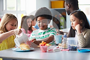 Group Of Children Eating Lunch In School Cafeteria photo