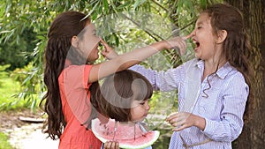 Group of children eating watermelon outdoors. Slow motion