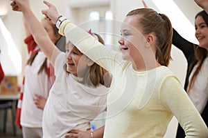 Group Of Children Enjoying Dance Lesson At Stage School Together