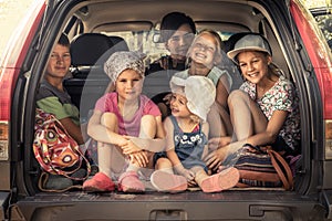 Group of children in family car trunk luggage going to road trip in family car symbolizing kids togetherness friendship and happy