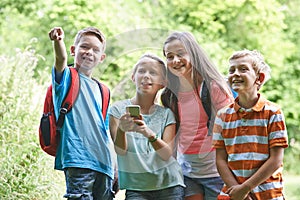 Group Of Children Geocaching In Woods