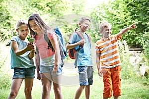 Group Of Children Geocaching In Woods