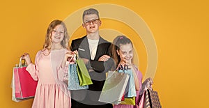 group of children go shopping. black friday concept. kids on cyber monday. big sale. teen girls and boy hold paper bag