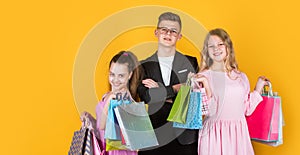 Group of children go shopping. black friday concept. kids on cyber monday. big sale. teen girls and boy hold paper bag