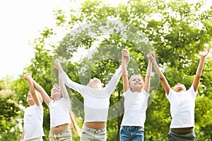 Group of children holding hands up. Volunteer project