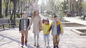 Group of children holding hands while walking at park