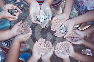 Group of children holding money in hands in the circle together