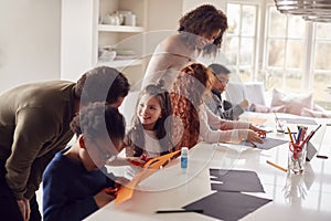 Group Of Children At Home With Parents Having Fun Making Craft Together