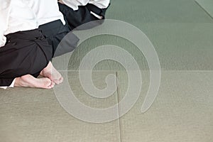 Group of children in kimono sitting on tatami on martial arts training seminar