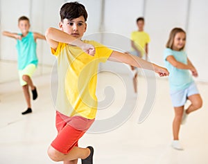 Group children learn dance movements in class