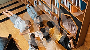 Group of children lying down in a circle while reading a book. Edification.