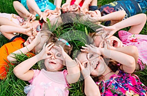 A group of children lying on the green grass in the Park. The interaction of the children.