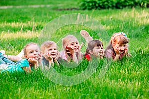 A group of children lying on the green grass in the Park. The interaction of the children.