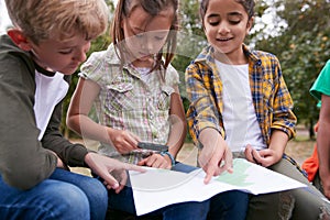 Group Of Children On Outdoor Activity Camping Trip Looking At Map Together photo