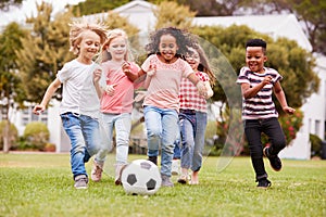 Group Of Children Playing Football With Friends In Park photo