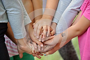 Group of children put their hands together.