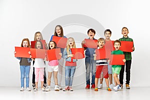 Group of children with a red banners isolated in white