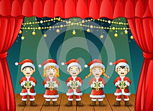 Group of children singing christmas carols on the stage