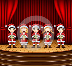 Group of children singing christmas carols on the stage