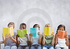 Group of children sitting and reading in front of grey background