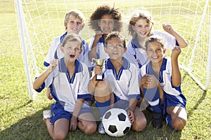 Group Of Children In Soccer Team Celebrating With Trophy