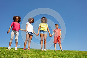 Group of children stand hold hand over clean sky