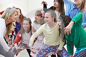 Group Of Children With Teacher Enjoying Drama Class Together photo