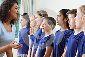 Group Of Children With Teacher Enjoying Singing Group