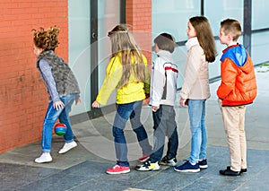 Group of children throwing ball to wall and jumping over