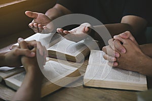 Group of christian people reading and study bible in home and pray together.