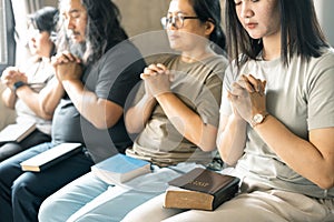 Group of Christian women sat together in chairs, holding their Bibles, feeling the togetherness of prayer and their religious