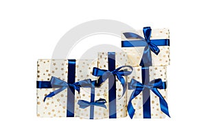 Group of Christmas or other holiday handmade present in gold paper with blue ribbon. Isolated on white background, top view.