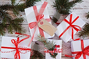 Group Christmas white gift boxes with red ribbons on white table. Top view