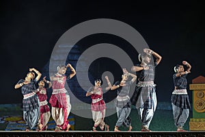 A group of Classical Odissi dancers performing Odissi Dance on stage at Konark Temple, Odisha, India.