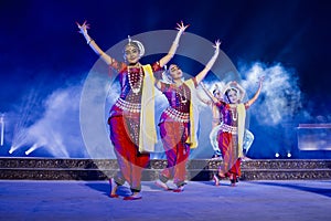 A group of Classical Odissi dancers performing Odissi Dance on stage at Konark Temple, Odisha, India.