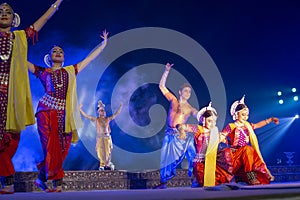 A group of Classical Odissi dancers performing Odissi Dance on stage at Konark Temple, Odisha, India.