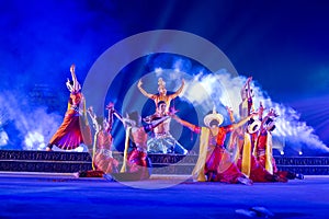 A group of Classical Odissi dancers performing Odissi Dance on stage at Konark Temple, Odisha, India.