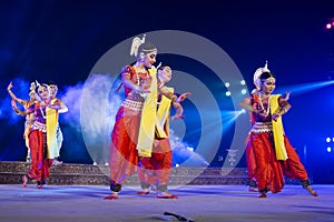 A group of Classical Odissi dancers performing Odissi Dance on stage at Konark Temple, Odisha, India.