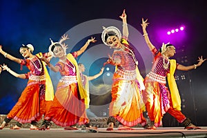 A group of Classical Odissi dancers performing Odissi Dance on stage at Konark Temple, Odisha, India.