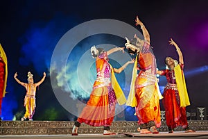 A group of Classical Odissi dancers performing Odissi Dance on stage at Konark Temple, Odisha, India.