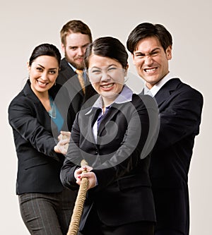 Group of co-workers pulling rope in tug-of-war