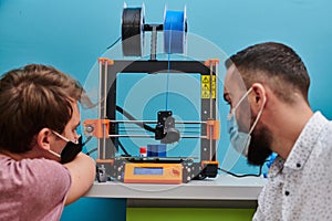 A group of colleagues collaborate in a lab while testing a 3D printer, demonstrating their commitment to technological
