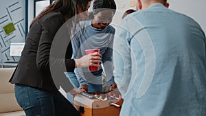 Group of colleagues playing at foosball table after work