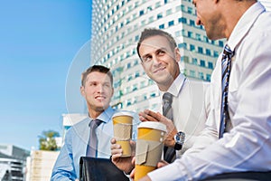 Group of colleagues sitting and talking while drinking coffee after work