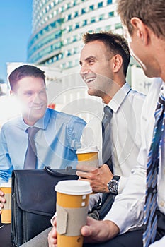 Group of colleagues sitting and talking while drinking coffee after work