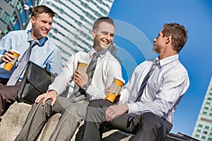 Group of colleagues sitting and talking while drinking coffee after work