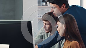 A group of colleagues working on a joint project and have a discussion near a computer. Teamwork concept