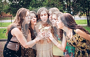 Group of College Girls Blowing Dandelion Seeds