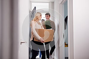 Group Of College Student Carrying Boxes Moving Into Accommodation Together