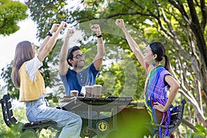 Group of college student is meeting and working on thesis and project outside in the university campus garden during summer